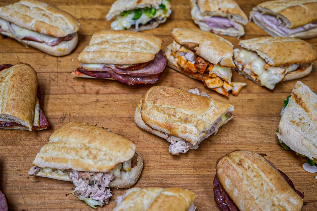 Various sandwiches with different fillings arranged on a wooden cutting board