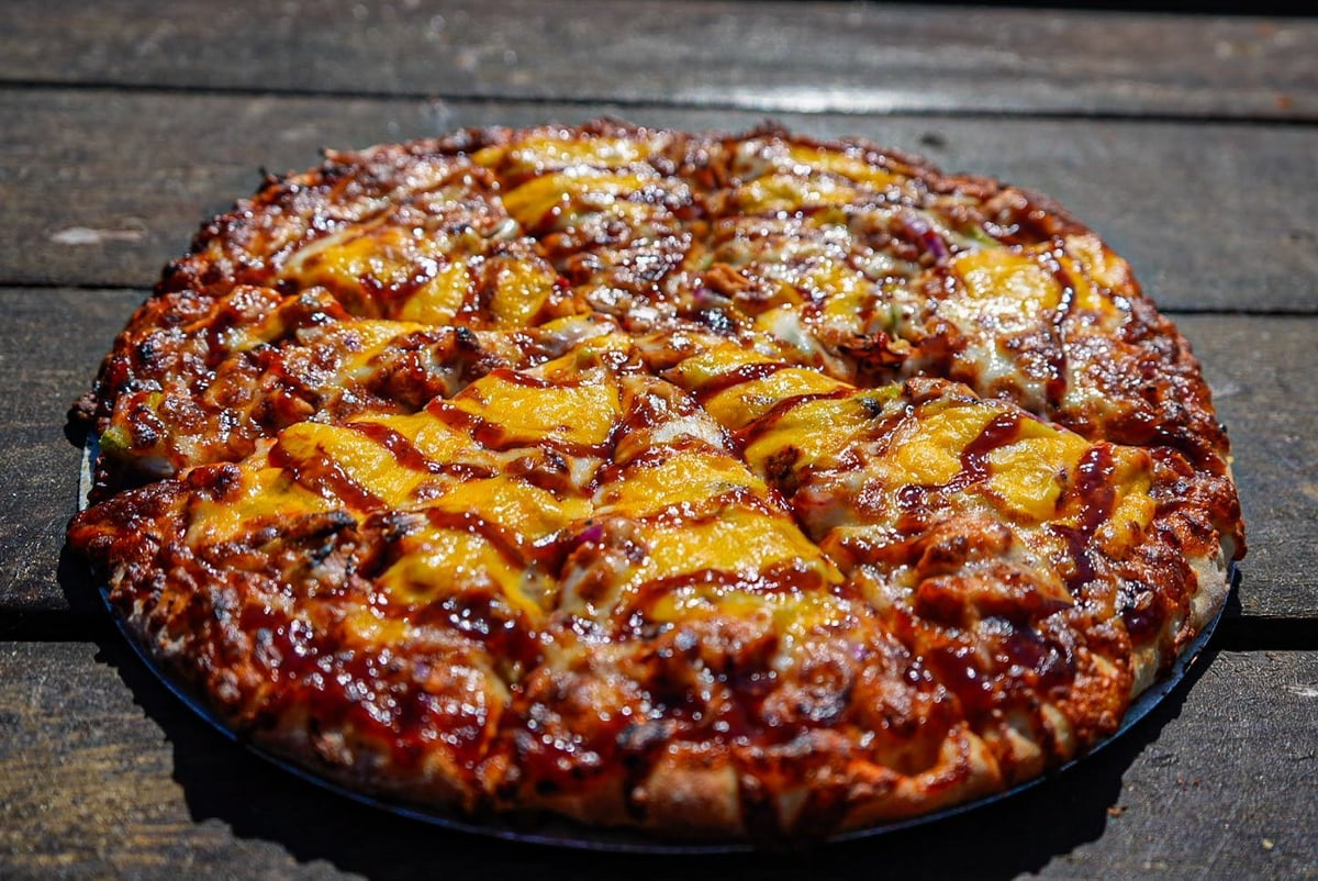 BBQ chicken pizza with chicken, red onions, and melted mozzarella